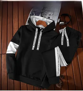 Close-up of black hoodie and joggers with white sleeve patches and lettered drawstrings