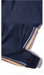Vue détaillée du vêtement de sport bleu marine montrant la bande rayée et la texture maille