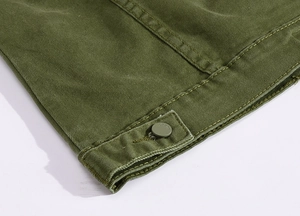 Dettaglio del polsino della giacca di jeans verde militare con doppia cucitura e bottone