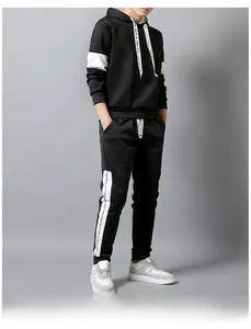 Detail of men's black tracksuit with white contrast side stripes and typographic lettering