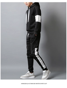 Detailed close-up of men's black sports tracksuit with side stripe branding details