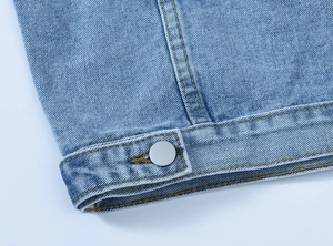 Detailed macro view of light blue denim fabric texture and orange contrast stitching detail