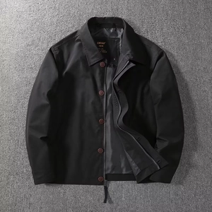Detail of black men's jacket featuring a classic collar with zipper and button closure