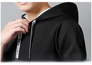 Detail view of black hoodie shoulder seams and branded drawstring texture