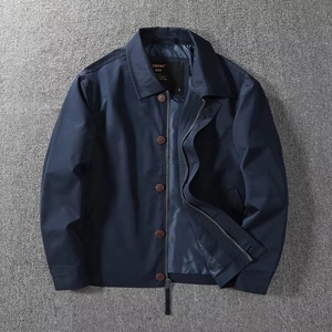 Detail view of navy blue Harrington jacket with classic collar and metallic zipper texture