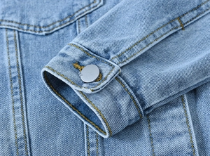 Blue denim jacket cuff detail featuring vintage silver metal button and contrast stitching