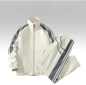 Flat lay of cream track suit featuring high neck zip jacket and side stripe pants