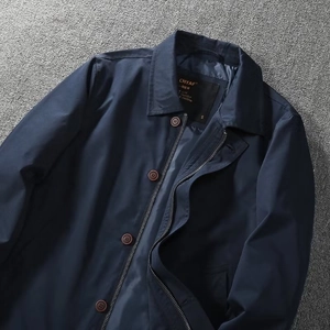 Detail of navy blue windproof jacket showing lapel collar with zip and button closure