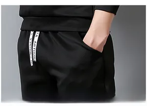 Detail of men's black joggers featuring contrast drawstring with letter print and side pockets