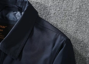 Close-up of navy blue jacket collar showing high-quality stitching and fabric texture