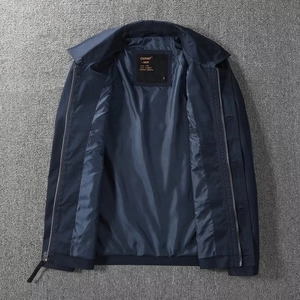 Detail of navy blue windbreaker jacket featuring double zipper and interior lining texture