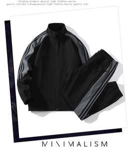 Detail of black sporty jacket and pants set featuring grey side stripes on sleeves and legs