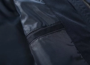 Detail view of navy blue windbreaker featuring inner zipper pocket and waterproof fabric