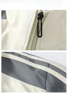 Detail view of cream jacket featuring gray paneling and black zipper hardware