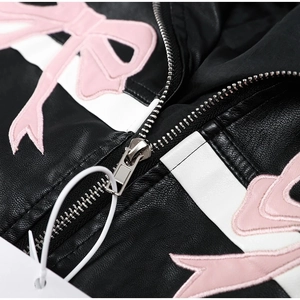 Macro shot of black PU leather jacket with pink bow embroidery and silver metal zipper