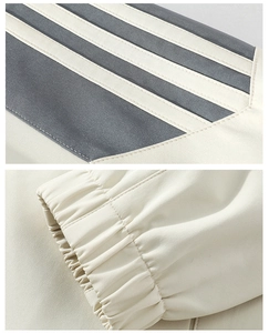 Detail of off-white athletic jacket with signature triple stripes and elastic cuffs