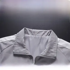 Détail du col montant et de la fermeture éclair sur une veste de sport gris clair