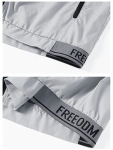 Detail of the elastic bottom hem with black lettering on a grey sun protection jacket