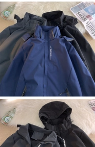 Close-up of technical outdoor hooded jackets in navy, black, and grey with explore lettering