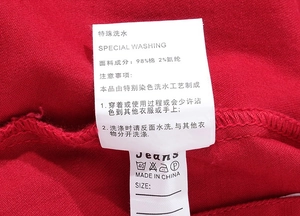 Dettaglio dell'etichetta di lavaggio con 98% cotone e 2% elastan sulla giacca denim