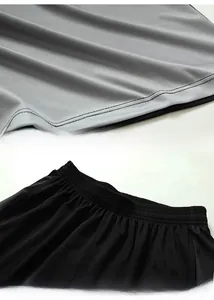 Detail of gray breathable mesh fabric and black elastic waistband on sports shorts