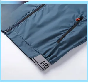 Detail of blue waterproof sun protection jacket showing grey elastic hem with FRI text