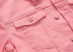 Dettaglio della giacca di jeans rosa con tasca a patta e bottone metallico testurizzato