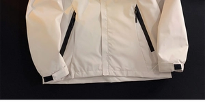 Detail of white functional jacket featuring waterproof fabric and adjustable velcro cuffs