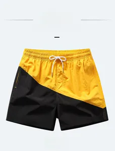 Detailed view of yellow and black quick-dry board shorts with adjustable drawstring waist