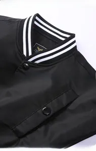 Detailed view of striped ribbed collar and snap buttons on black bomber jacket