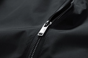 Dettaglio del tessuto in nylon nero ad alta densità con cursore della cerniera in argento