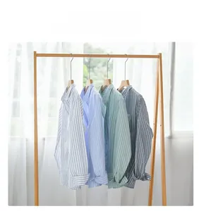 Detailed view of striped cotton shirts in four colors hanging on wooden hangers