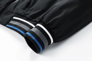 Dettaglio di polsini e orlo in maglia a costine con strisce tricolori su giacca nera