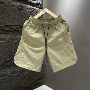 Detail of army green quick-dry shorts featuring elastic waist with black drawstring