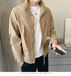 Detailed view of khaki utility jacket with stand collar, zipper, and chest patch detail