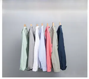 Detailed row of linen cotton shirts in multiple colors on wooden hangers with soft texture