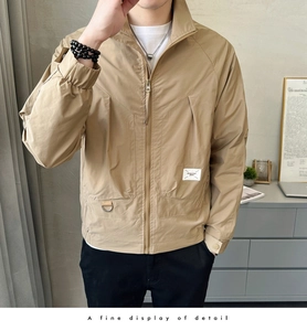 Detail of khaki jacket showing stand collar, cargo pockets and metallic D-ring trim