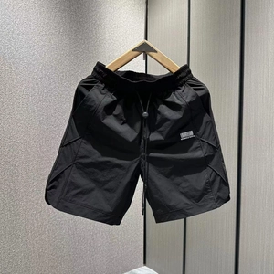 Detail of men's quick-dry shorts featuring elastic drawstring waist and side letter print