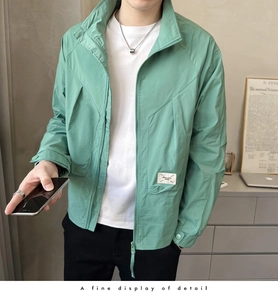 Detailed close-up of mint green men jacket zipper pocket and white square woven label
