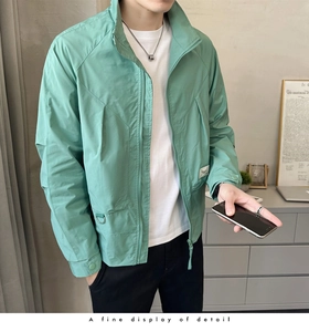 Detail of mint green lightweight windbreaker jacket with utility pockets and stand collar