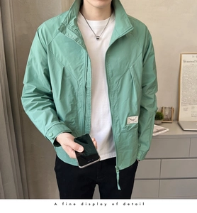 Close-up of mint green men's jacket featuring a stand collar and woven brand label detail