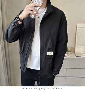 Close-up of black stand-up collar jacket with white woven label and zipper detail