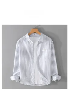 Detail of blue striped cotton shirt with chest pocket and decorative label on hanger