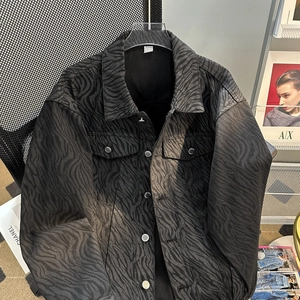 Detailed view of dark grey zebra pattern denim jacket with flap pockets and buttons
