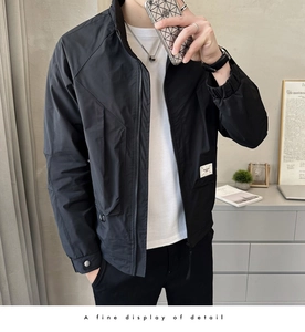Detail showing casual black jacket with stand collar and white woven label on the hem
