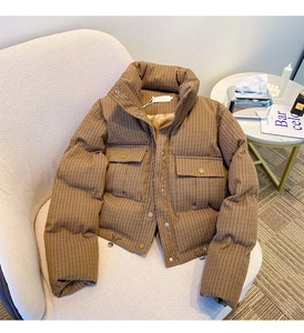 Detail of coffee brown quilted winter coat with stand collar and metallic snap buttons