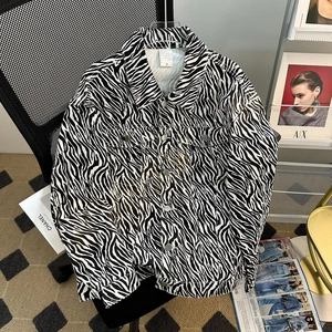 Detail of zebra print denim jacket featuring metal buttons and front chest pockets