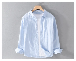 Detail of light blue linen shirt texture with lapel collar hanging on a wooden hanger