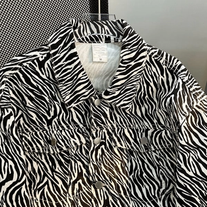 Detail view of Zebra pattern denim jacket showing collar label, size M and metal buttons