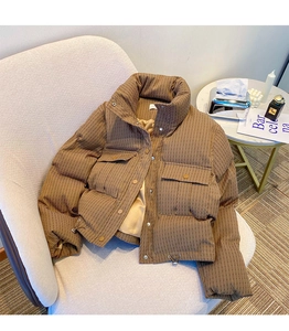 Detail of a brown textured puffer jacket with large flap pockets and drawstrings